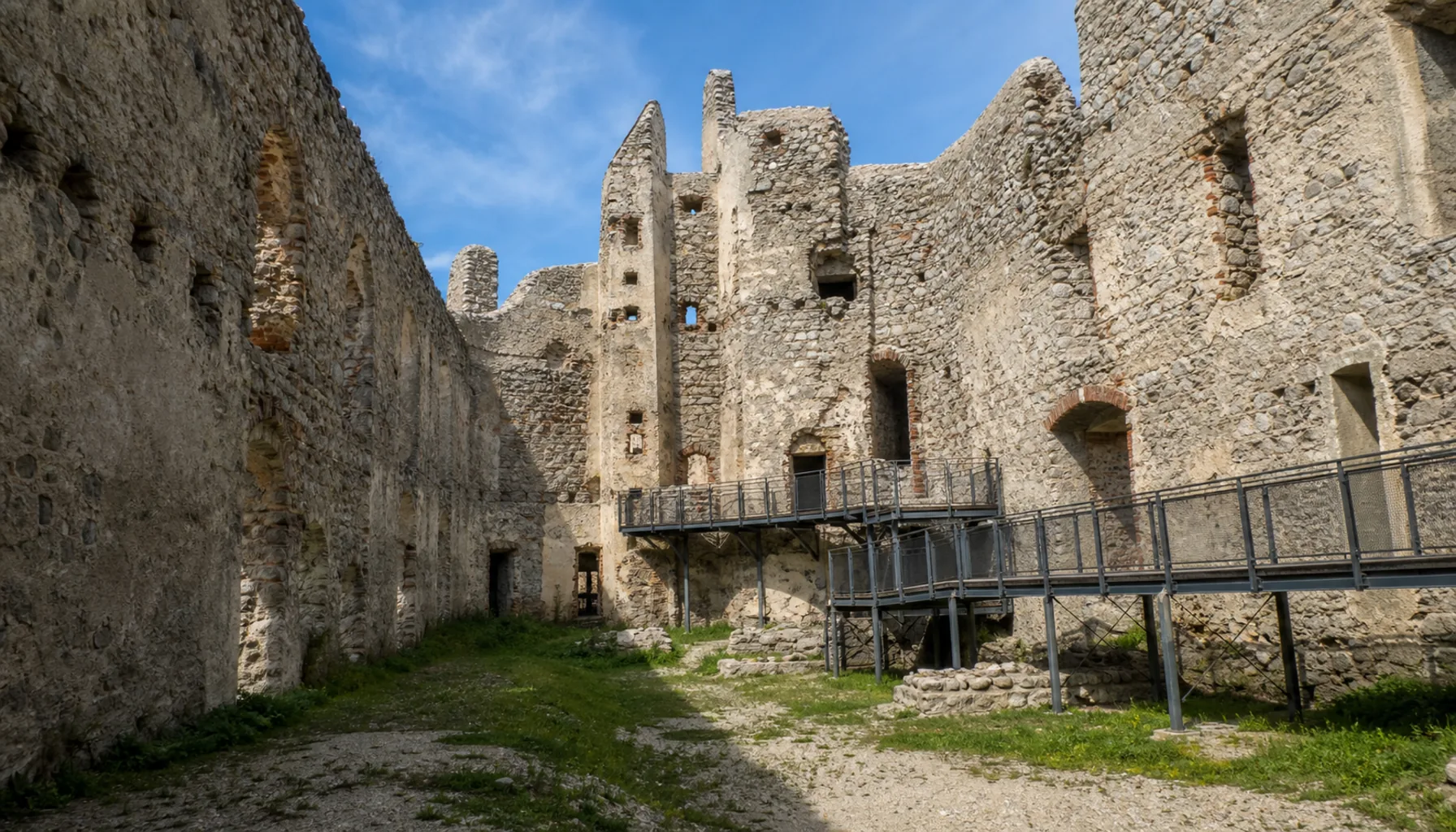 Roofless palace walls in the upper courtyard, with the visitor walkway threading between them