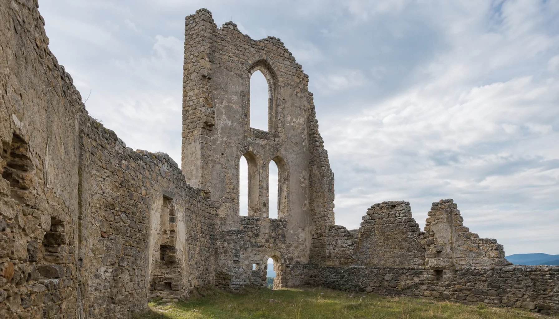The roofless walls of the castle chapel, its window openings now framing nothing but sky