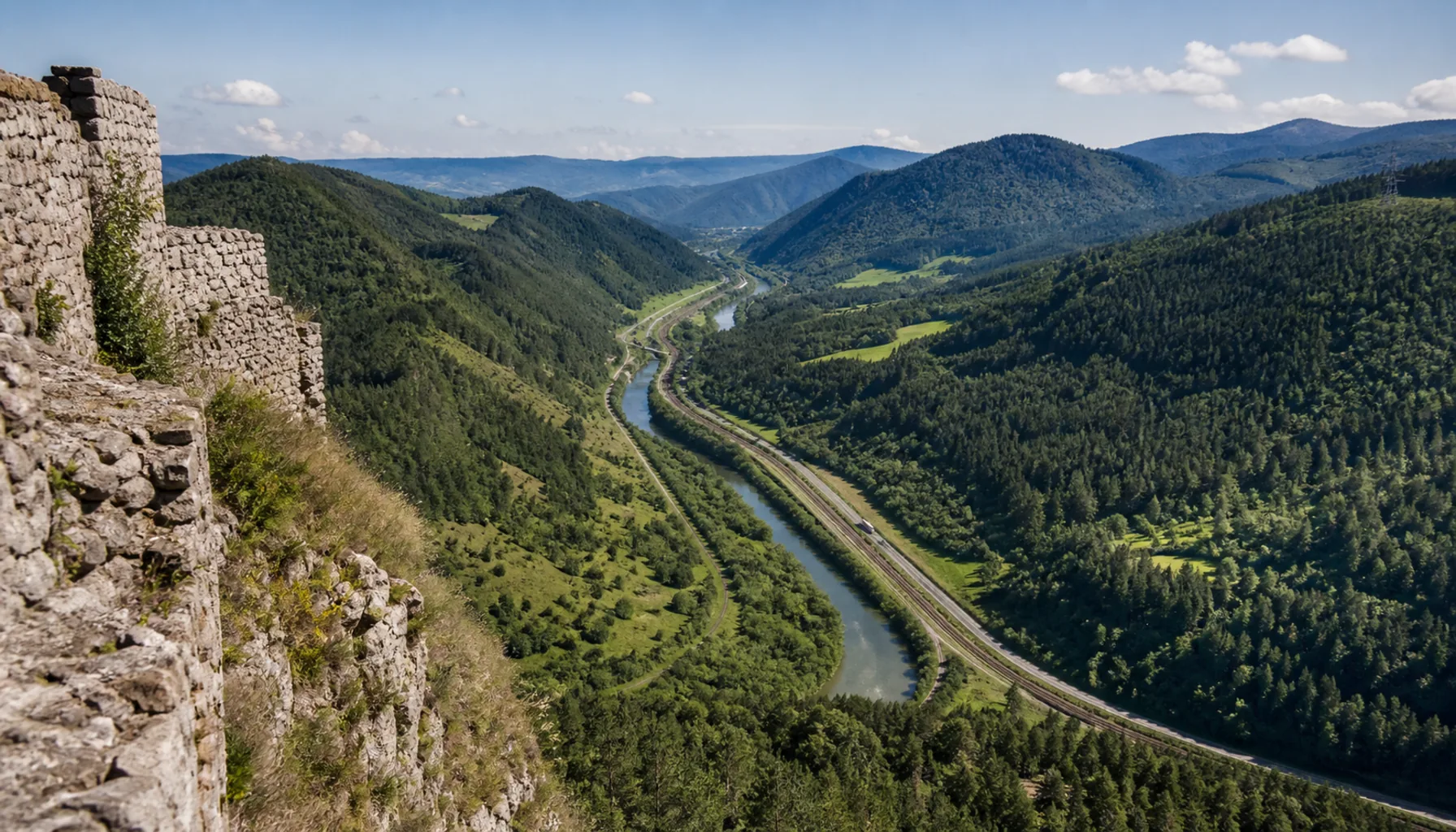 The Hron valley from the castle edge, opening north toward the mining hills