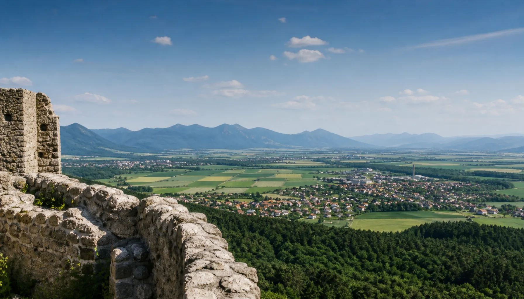 The Turiec basin from the castle walls — flat green floor between two mountain ranges