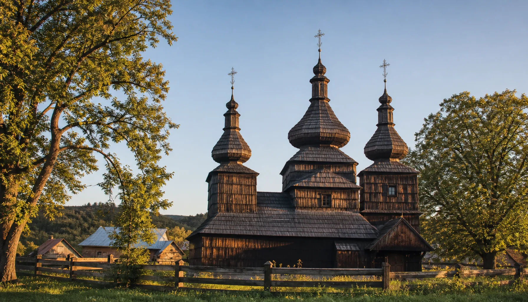 Three onion-domed towers of a Greek Catholic wooden cerkov rise over a Rusyn village in northeastern Slovakia