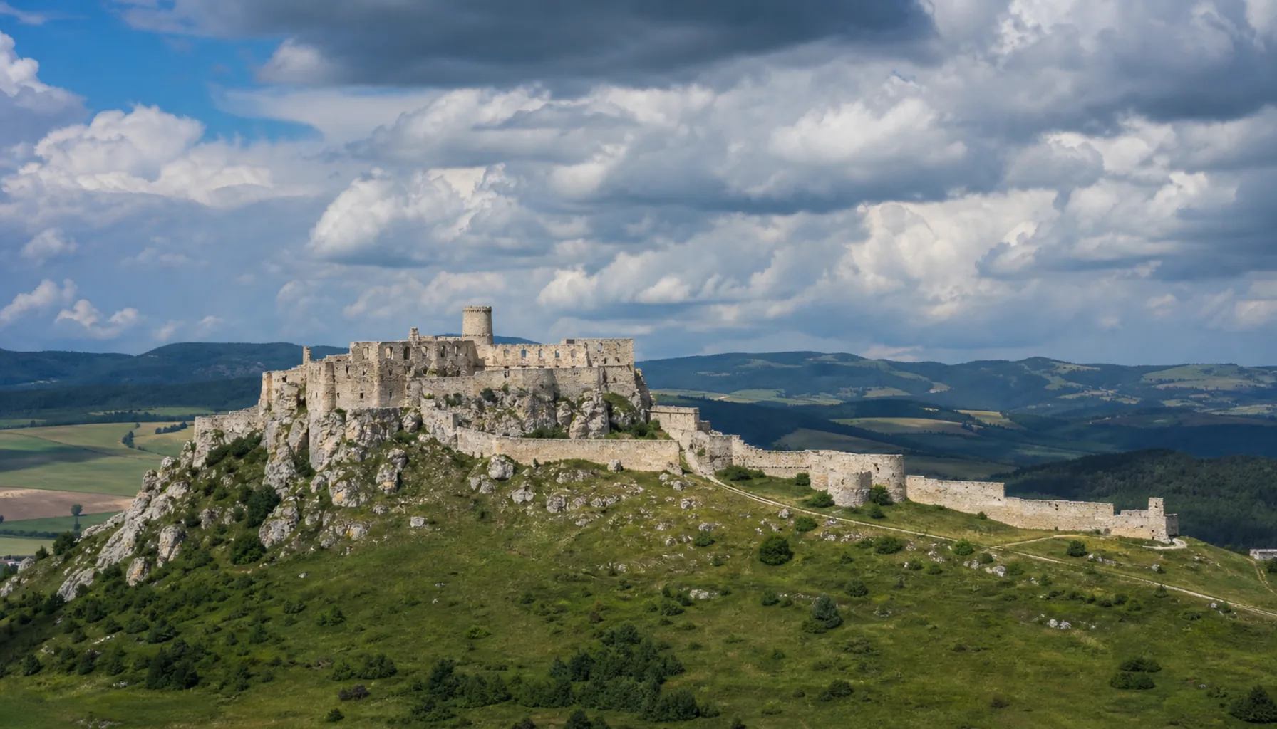 The white ramparts of Spiš Castle on their travertine hill — the stone-castle kingdom at its grandest