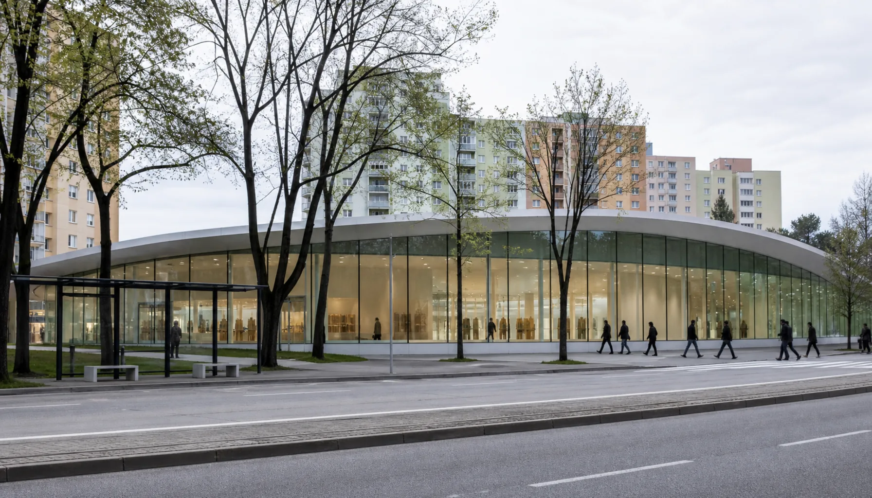 The low glazed frontage seen from the boulevard, with the housing blocks of the plateau rising directly behind it