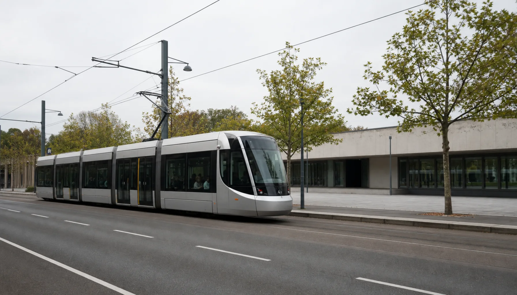 A tram passing on Vajnorská, overhead wires against the sky and the long building set back behind its forecourt
