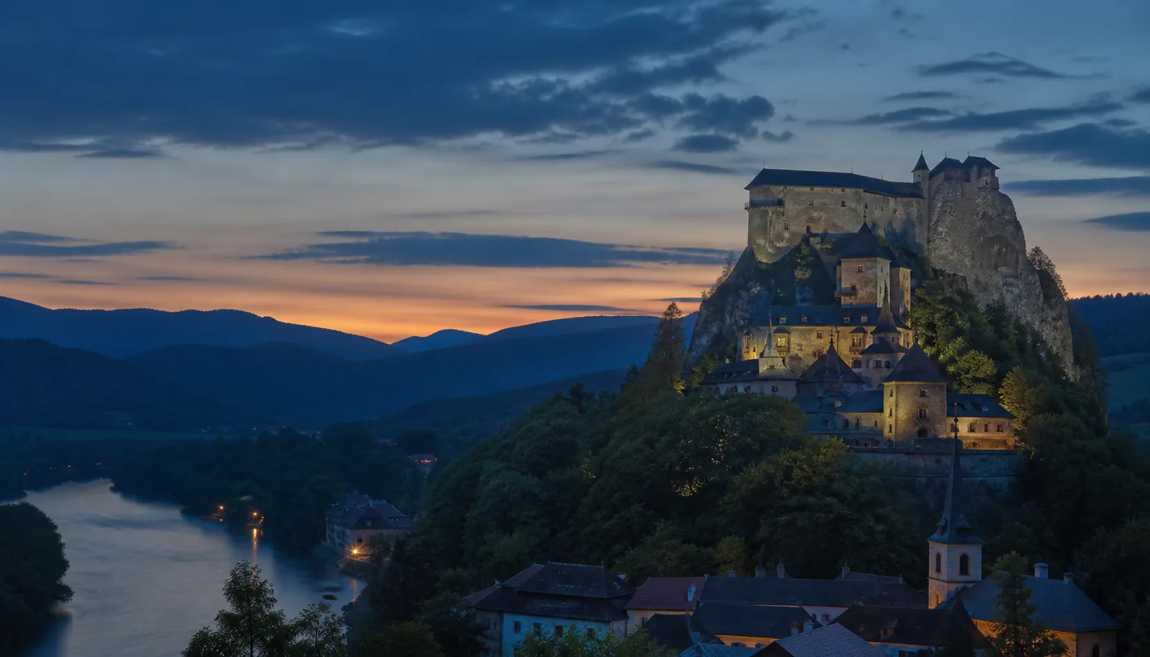 Orava Castle at twilight — page background