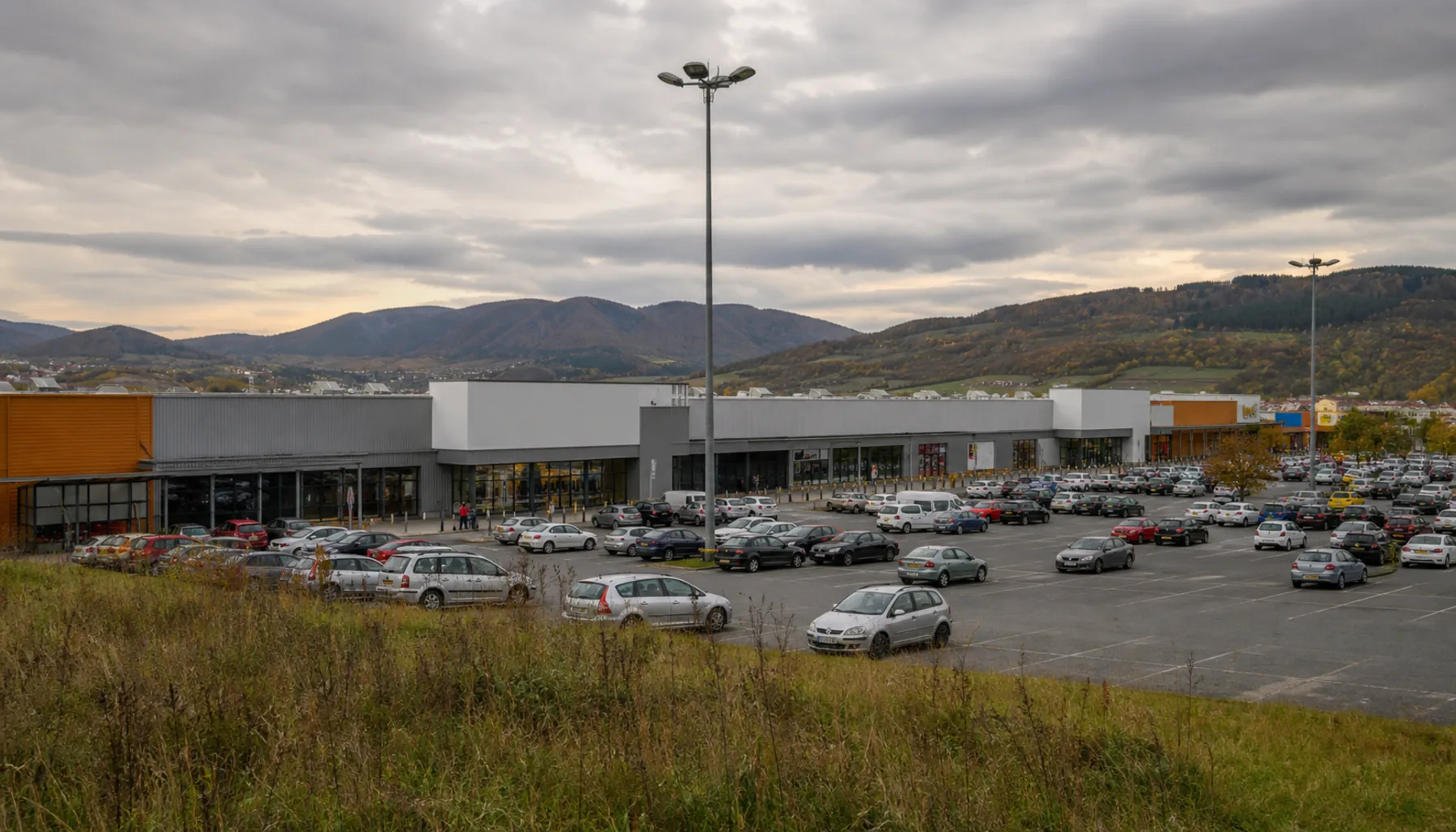 The wide low frontage and car park of an out-of-town shopping centre on the edge of Trenčín