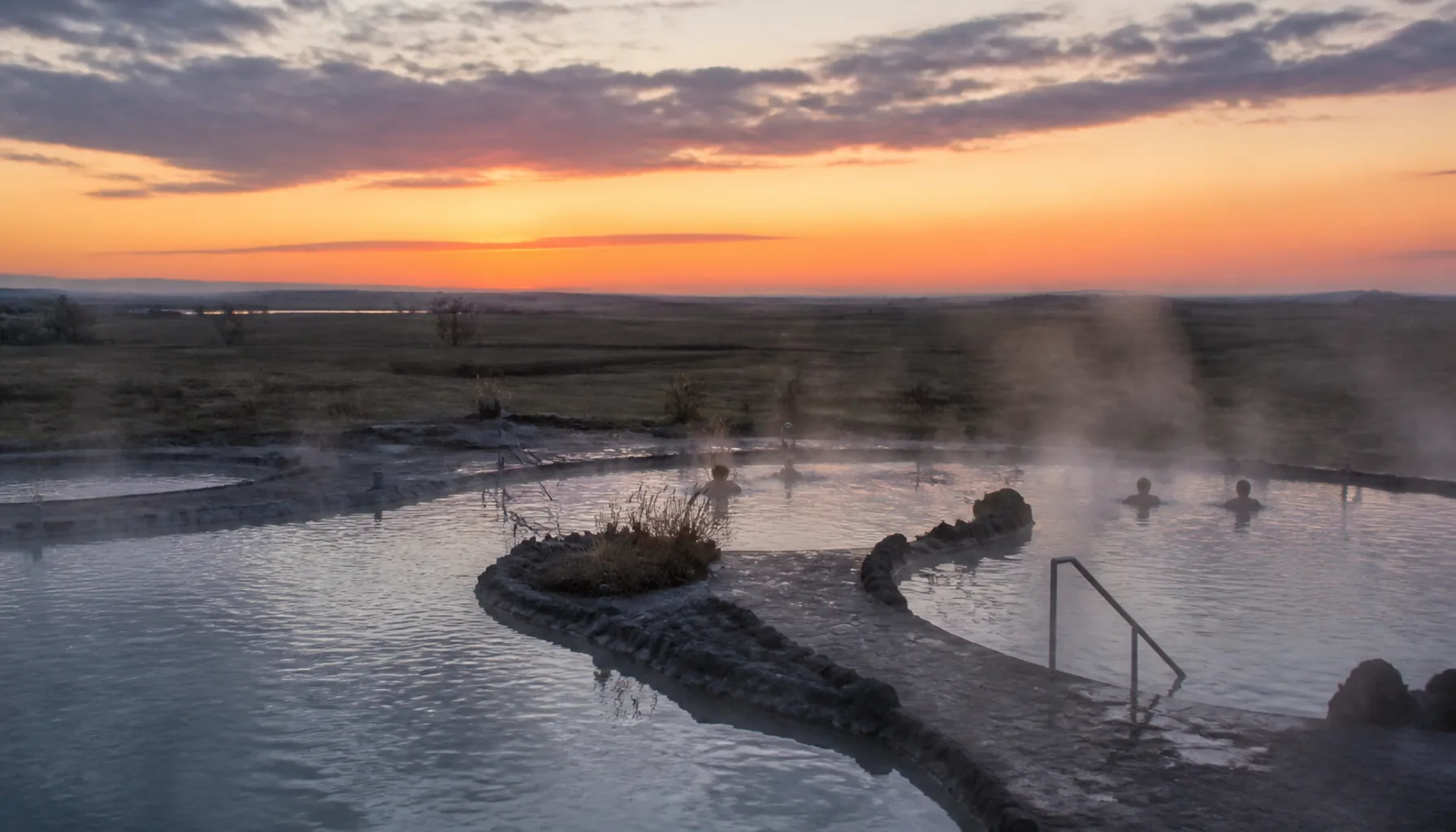 Thermal bathing on the Nitra lowland: open pools steaming above flat arable country at dusk