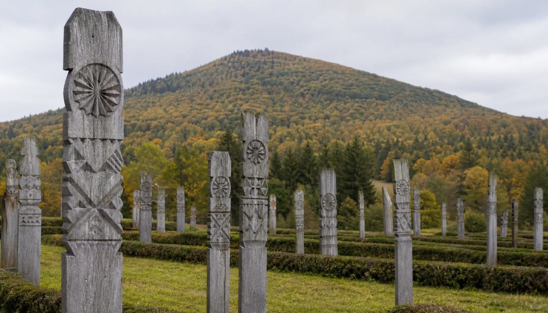 Carved oak grave crosses in the cemetery at Detva, with Poľana behind