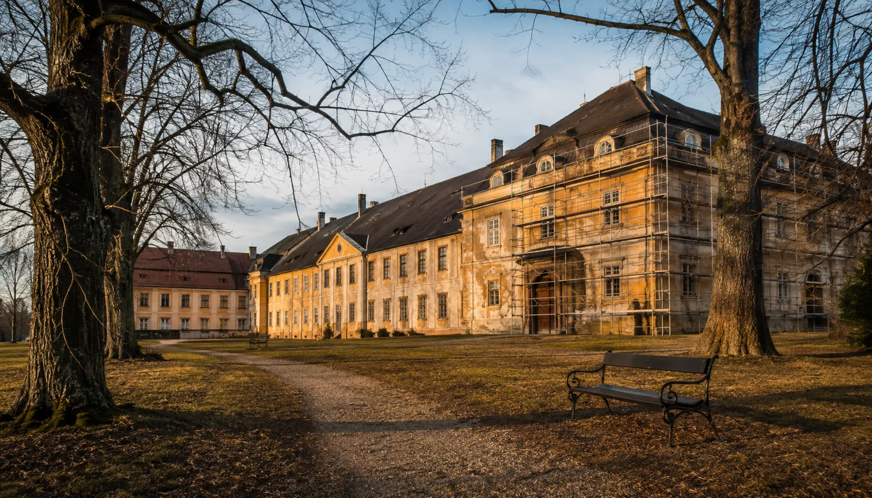 The Illésházy manor house across its park in Dubnica nad Váhom, one wing under the scaffolding of a restoration that has run in stages for years