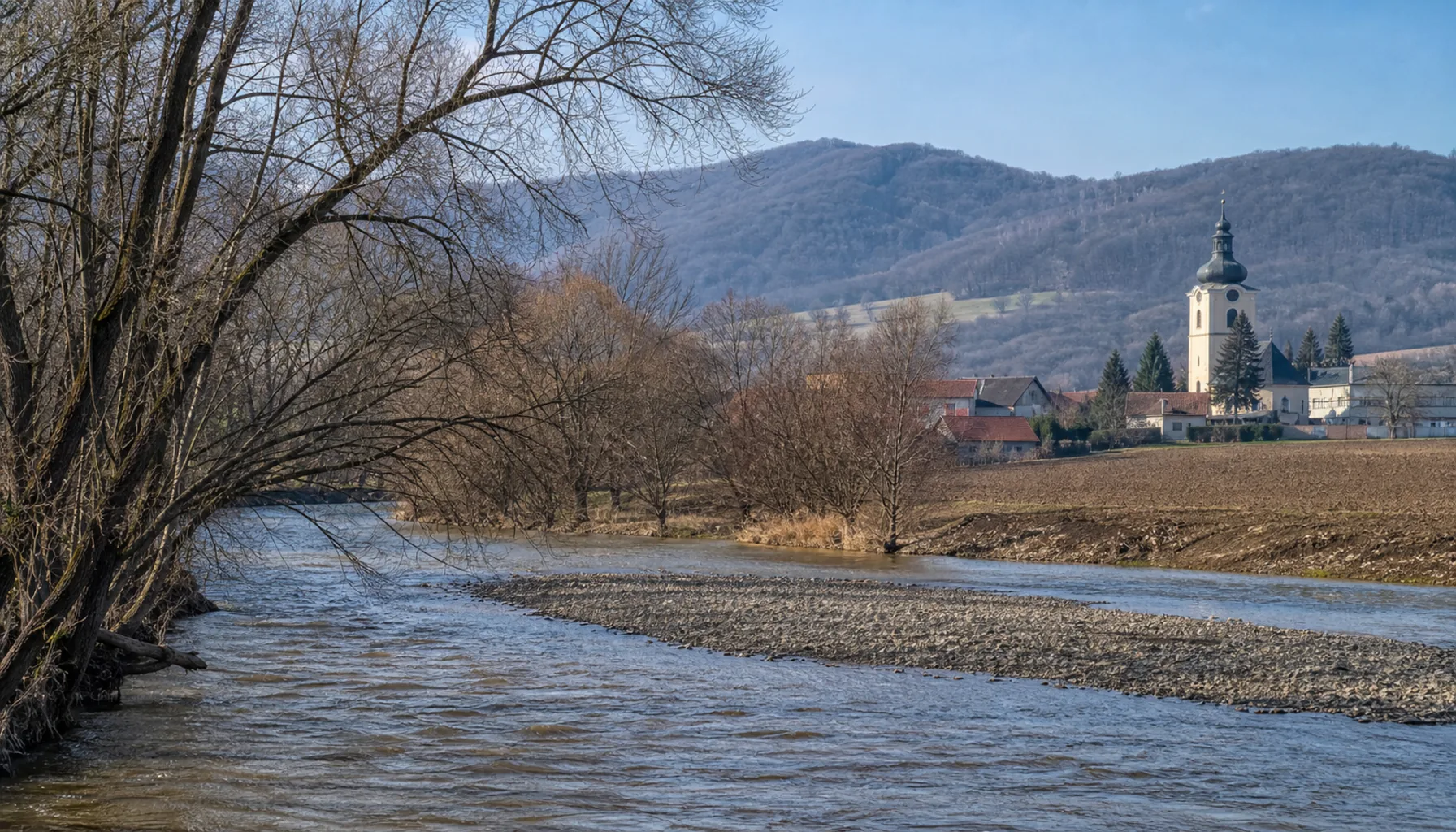The Topľa running past Giraltovce under the rounded forested hills of the Ondava Highlands