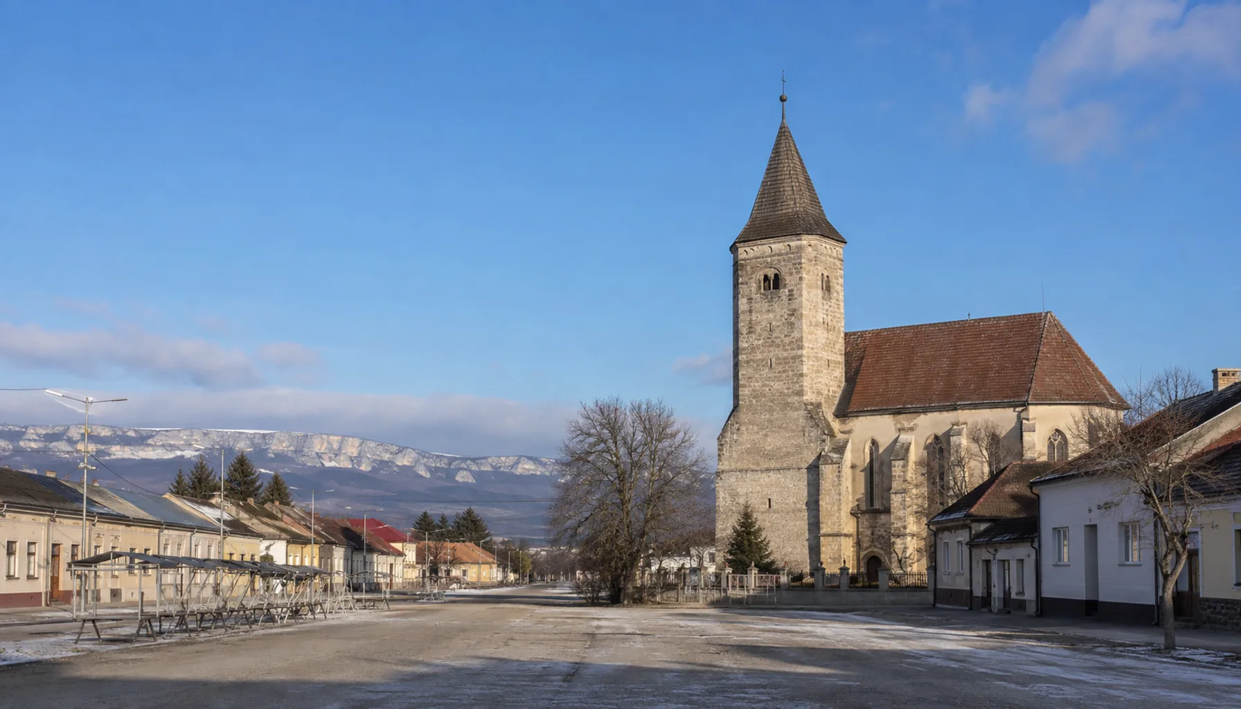 The market square and the Gothic parish church of Moldava nad Bodvou, with the first limestone of the Slovak Karst behind
