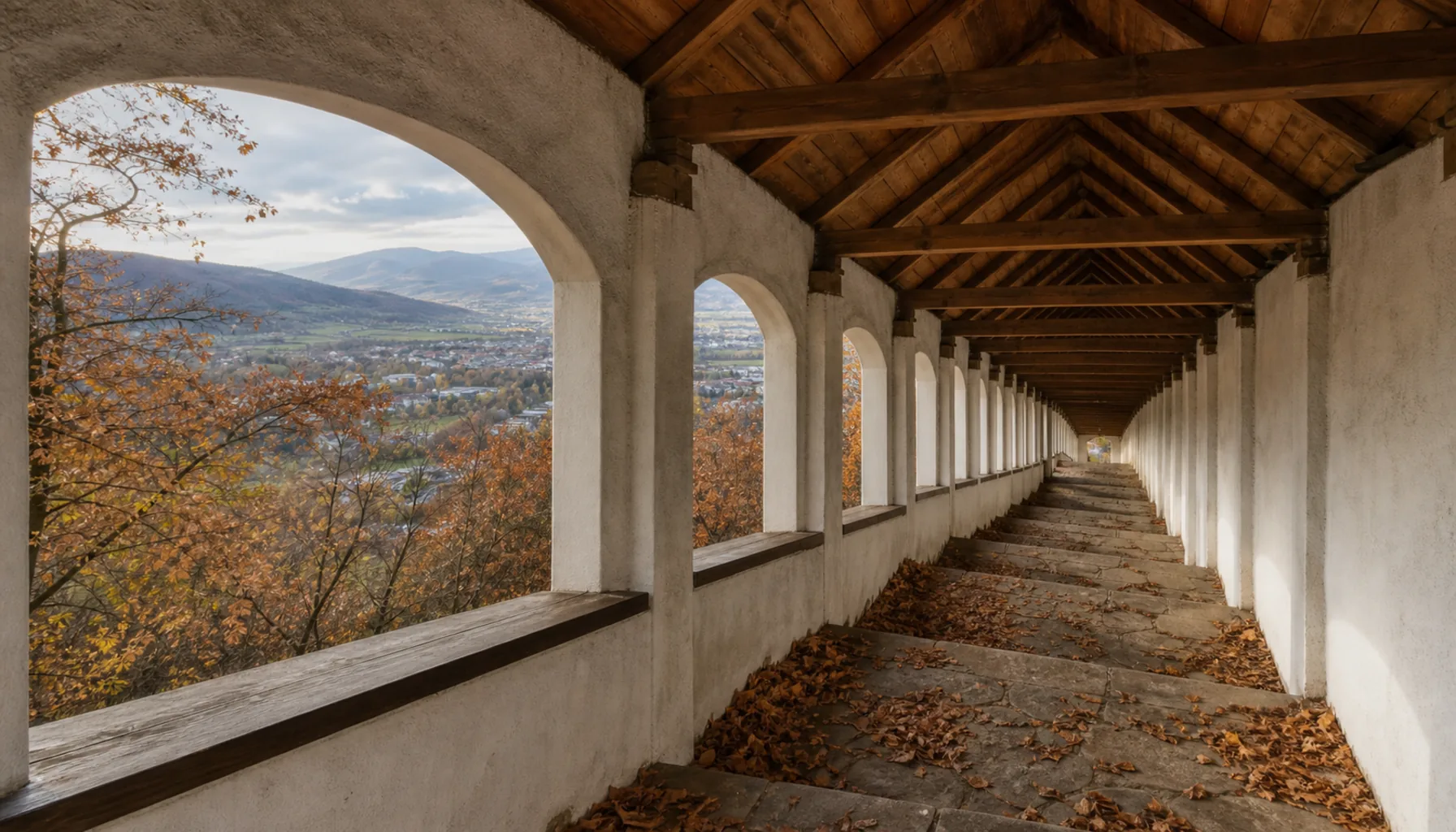 The covered stairway climbing Prievidza's Marian hill to the pilgrimage church, with the Upper Nitra basin opening out behind it