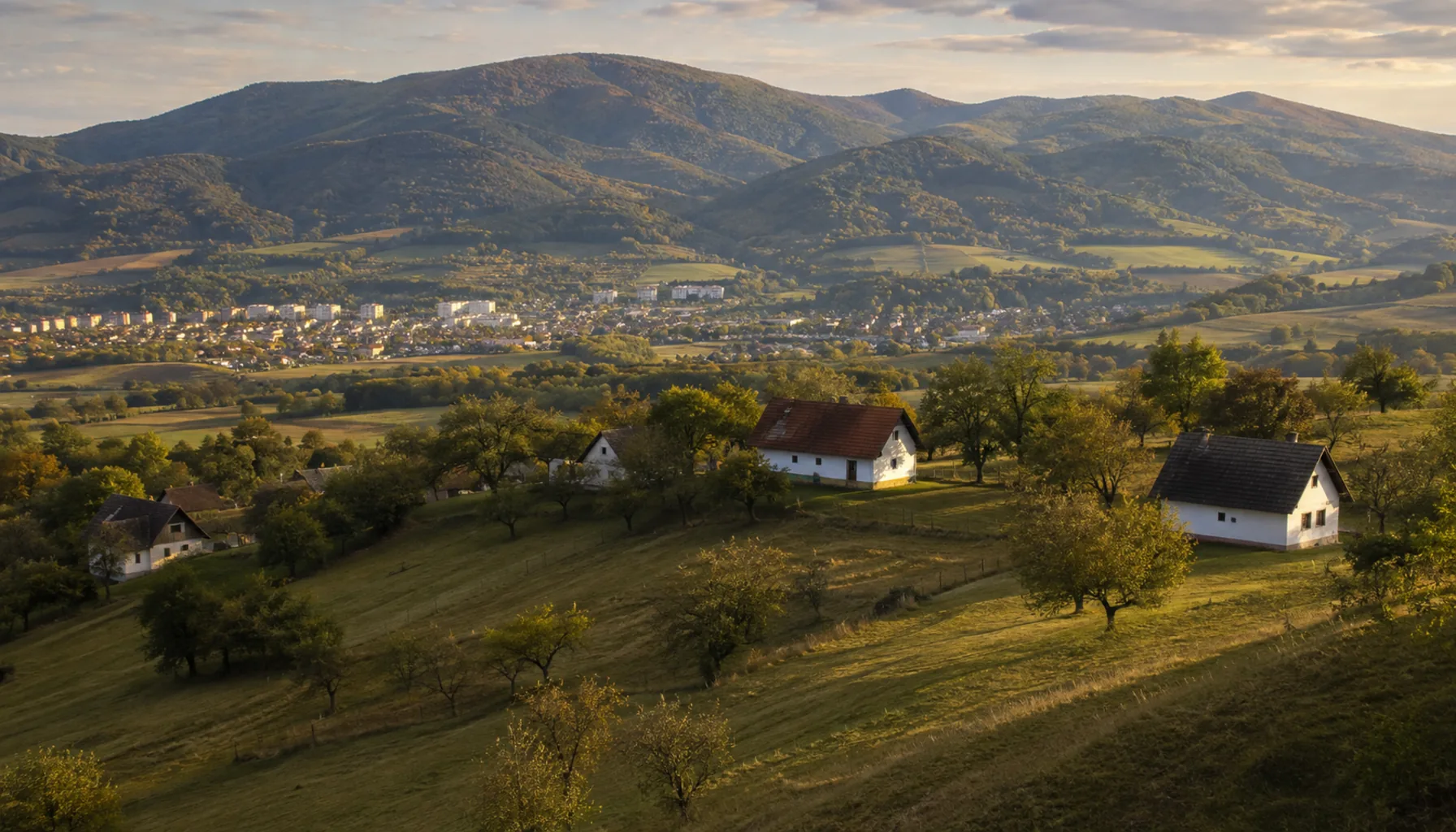 Kopanice farmsteads scattered along the ridges above Stará Turá, with plum orchards and hay meadows between them in late September
