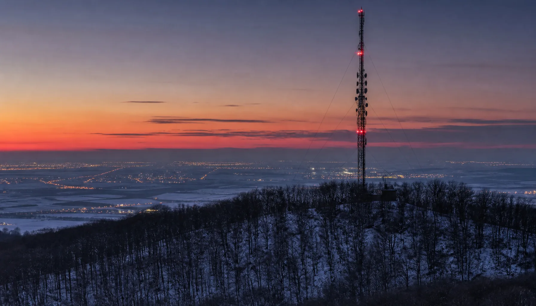A television transmitter mast above the lowland at winter dusk